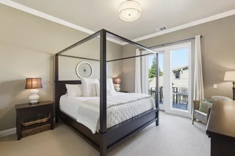 a bedroom with a bed a lamp and a large window