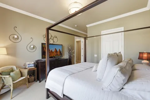 a bedroom with a bed and a painting on the wall