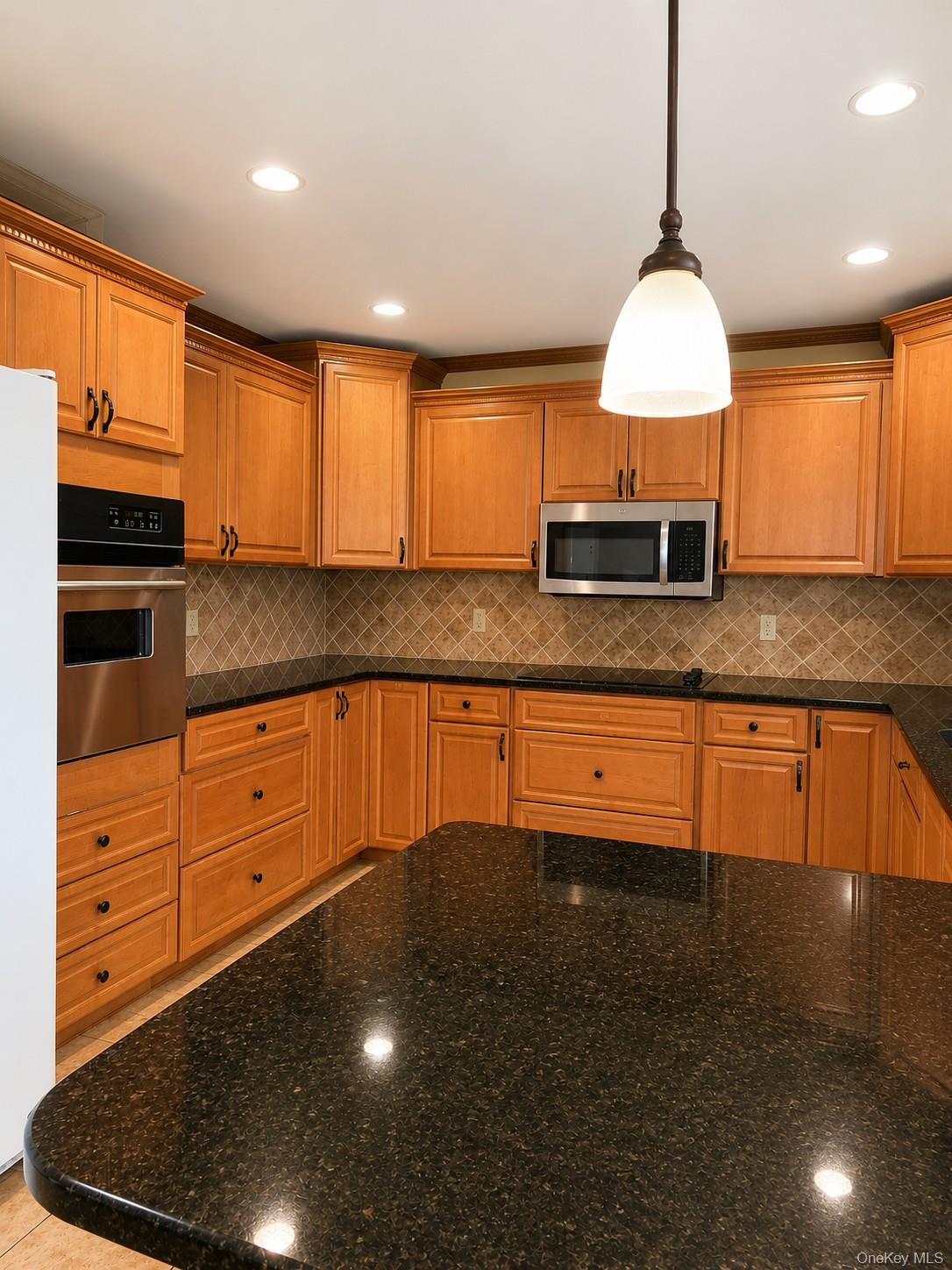 180 Sutton Manor Road New Rochelle, NY 10801 - Photo 3 of 9 a kitchen with granite countertop a stove a sink and a refrigerator