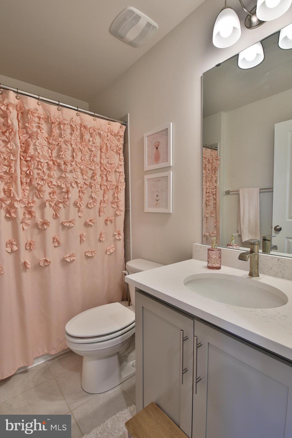 5059 Silver Oak Drive Rosedale, MD 21237 - Photo 24 of 43 a bathroom with a sink a toilet a mirror and shower curtain