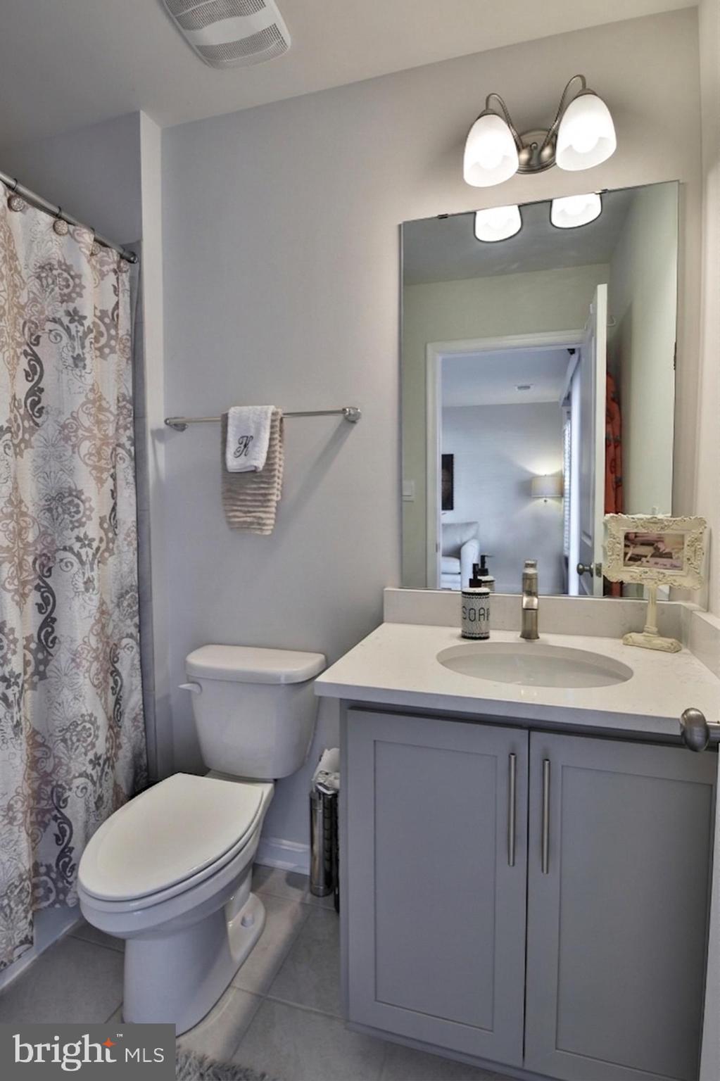 5059 Silver Oak Drive Rosedale, MD 21237 - Photo 31 of 43 a bathroom with a toilet a sink and mirror