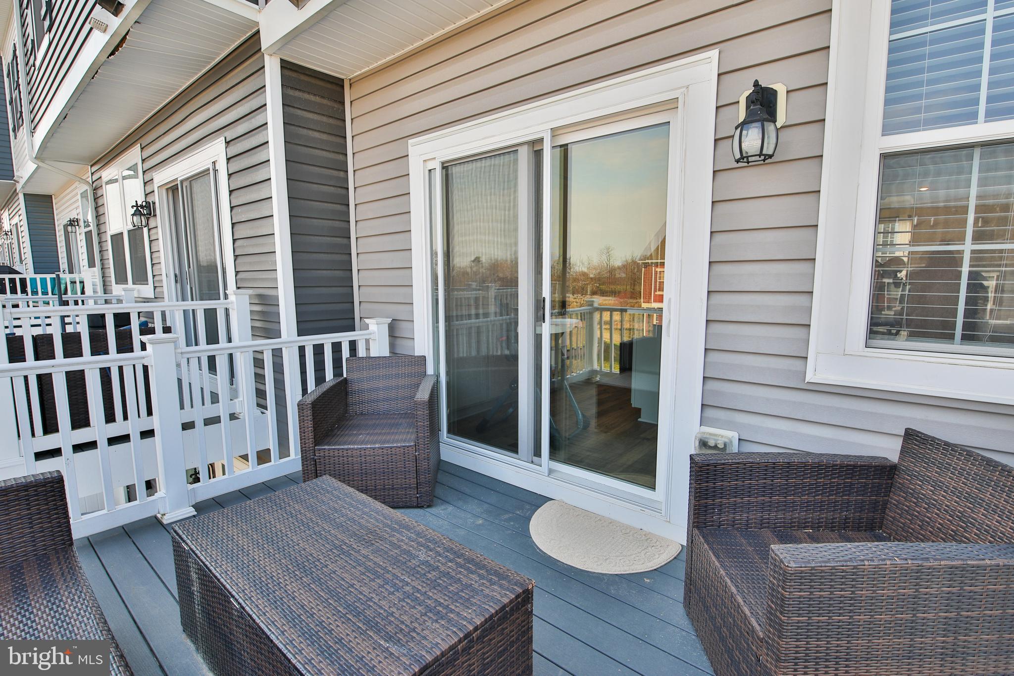 5059 Silver Oak Drive Rosedale, MD 21237 - Photo 35 of 43 a view of a deck with couches chair and wooden floor