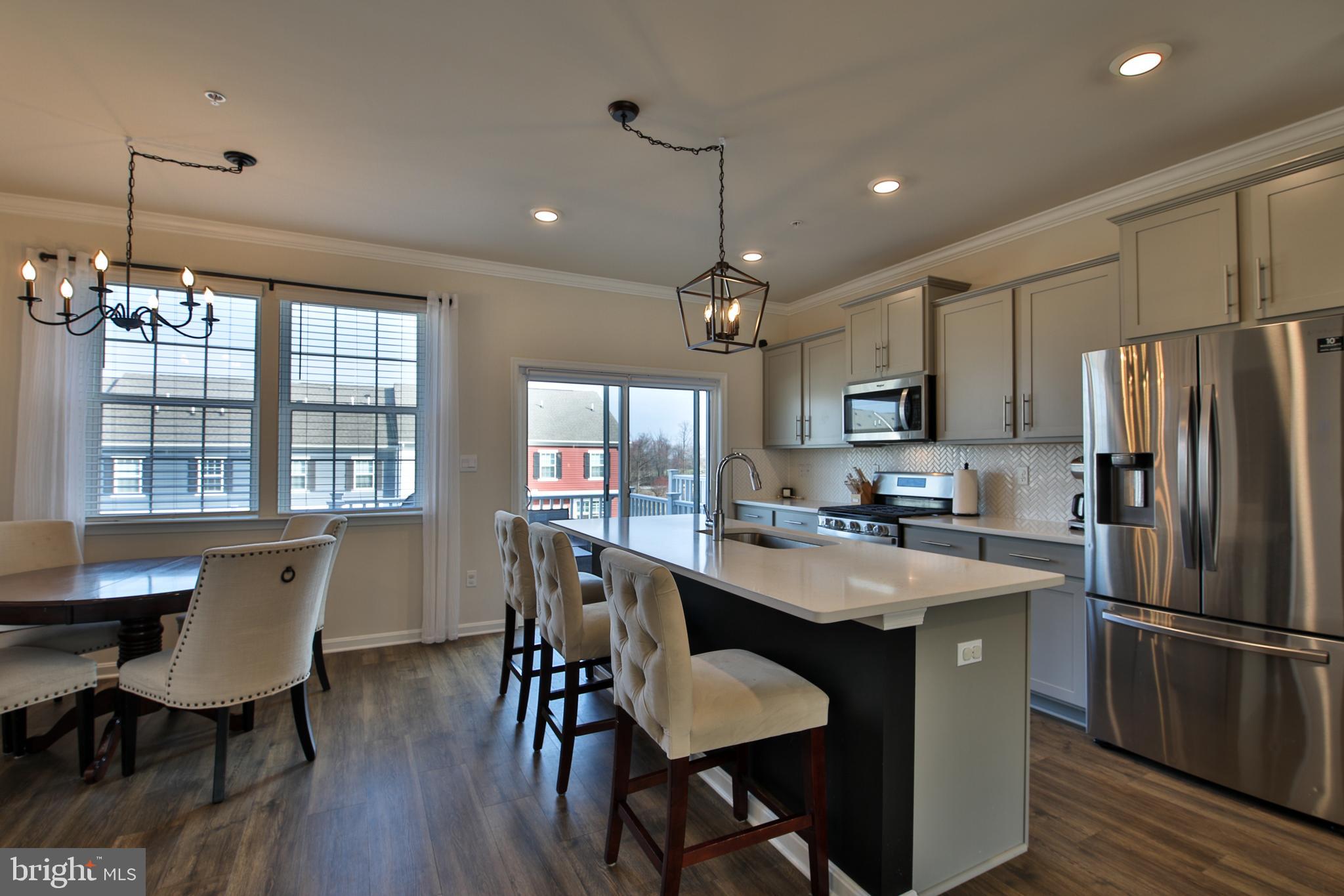 5059 Silver Oak Drive Rosedale, MD 21237 - Photo 7 of 43 a kitchen with kitchen island a dining table and chairs