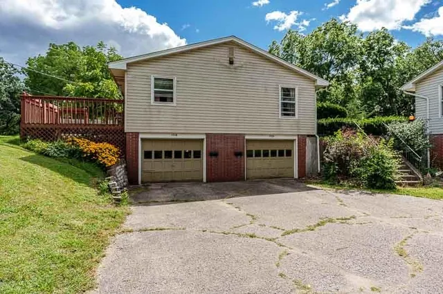 a view of a house with a yard and potted plants