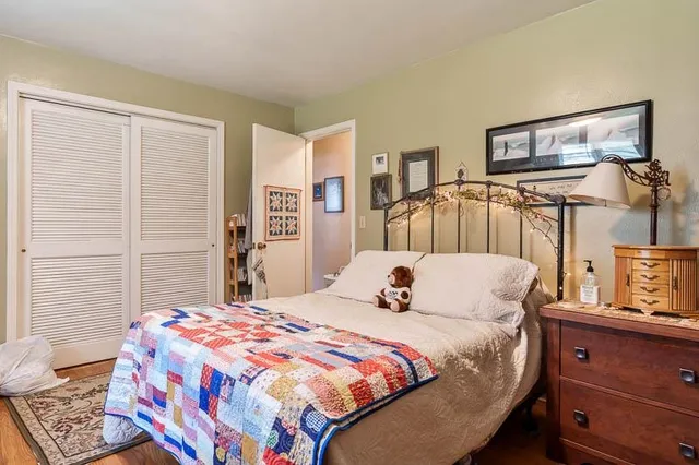 a bedroom with a bed a mirror and a window