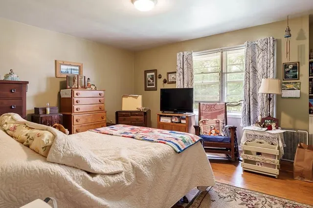 a bedroom with furniture and a large window