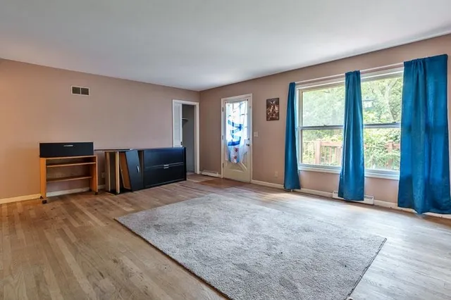 a living room with furniture a flat screen tv and a floor to ceiling window