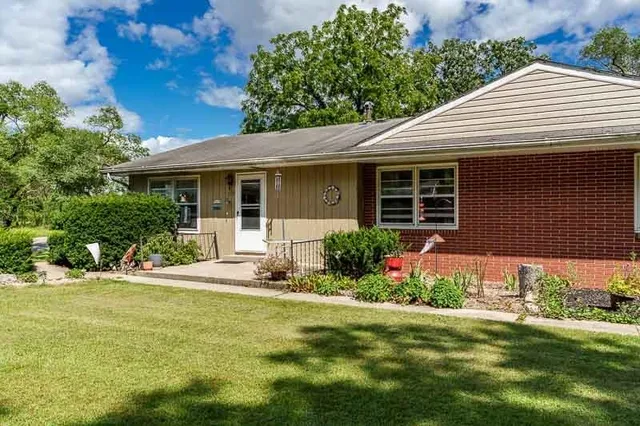 a front view of a house with a yard and potted plants
