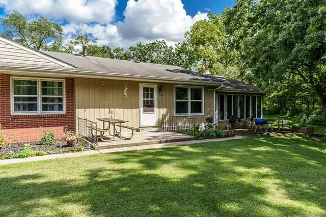 a view of a house with backyard and sitting area