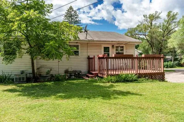 a view of a house with a yard and a large tree