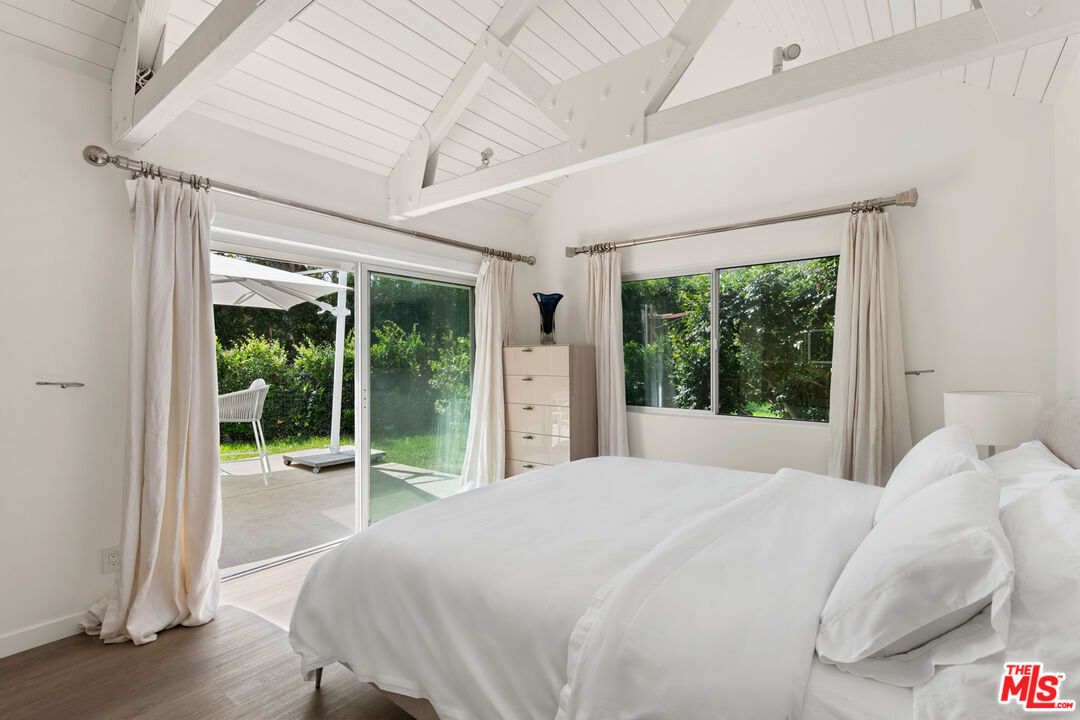 5949 Ramirez Canyon Road Malibu, CA 90265 - Photo 17 of 26 a bedroom with a bed and a large window with outer view