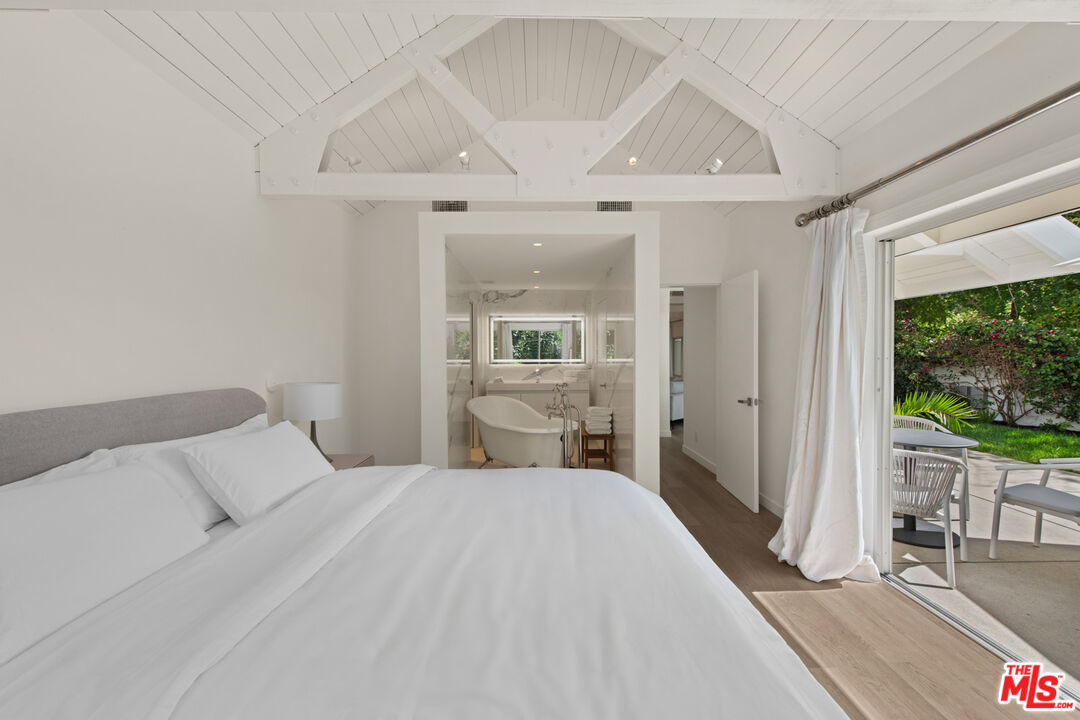 5949 Ramirez Canyon Road Malibu, CA 90265 - Photo 19 of 26 a bedroom with a large bed and a large window