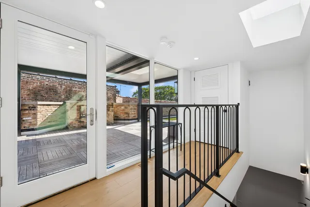 a view of a hallway with wooden floor and windows