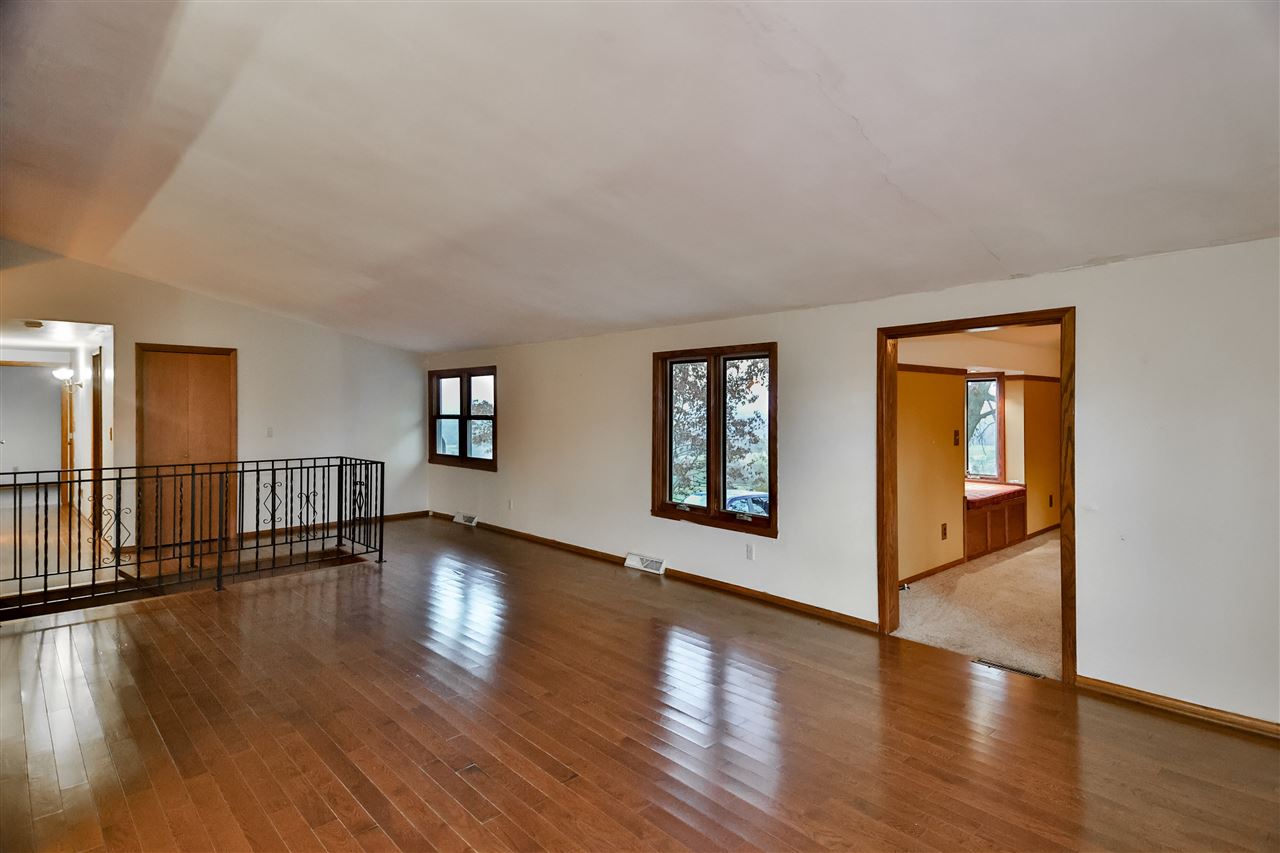 118 North Elizabeth Scales Mound Road Elizabeth, IL 61028 - Photo 14 of 40 a view of an empty room with wooden floor and a window