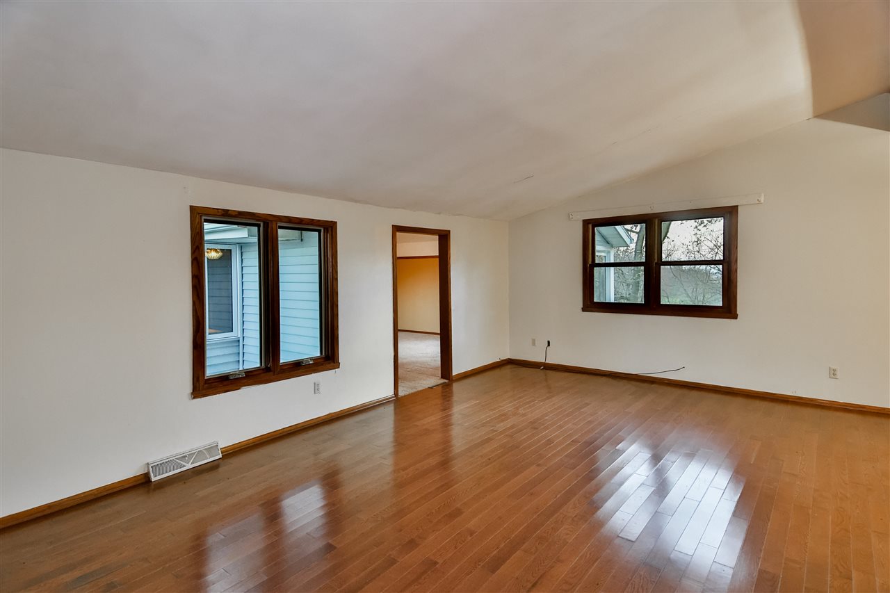 118 North Elizabeth Scales Mound Road Elizabeth, IL 61028 - Photo 10 of 40 a view of an empty room with wooden floor and a window