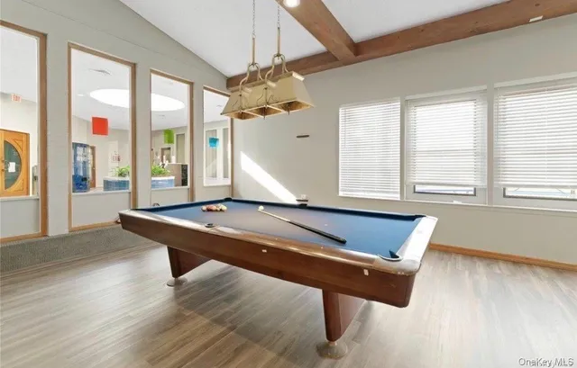 a swimming pool with outdoor seating and yard in the back