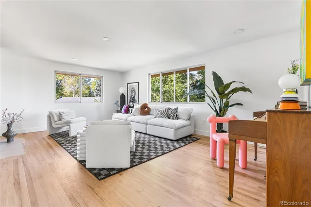 a living room with furniture a window and wooden floor