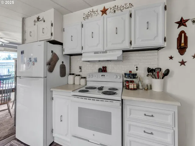 a kitchen with white cabinets and white appliances