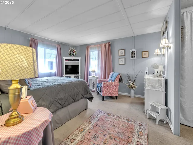 a spacious bedroom with a bed and wooden floor