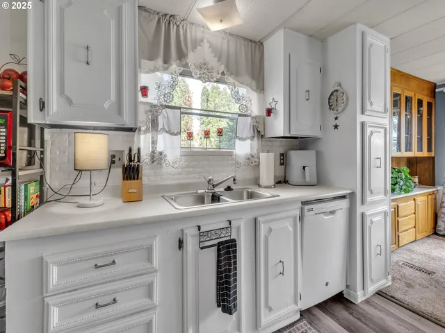 a kitchen with white cabinets and window