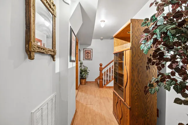 a view of a hallway with wooden floor and staircase