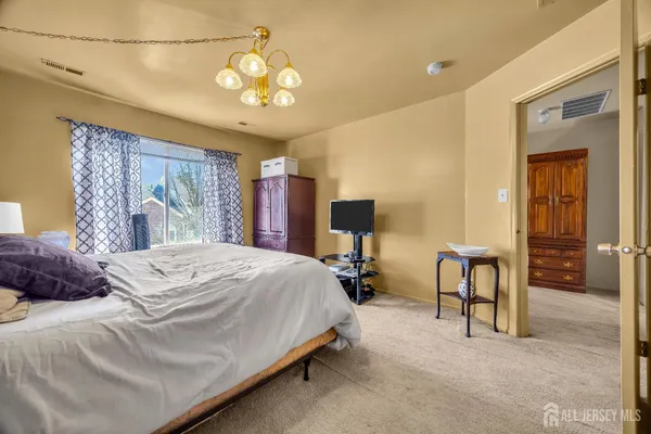 a bedroom with a bed and a chandelier