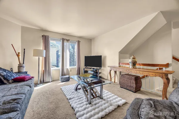 a living room with furniture a flat screen tv and a table