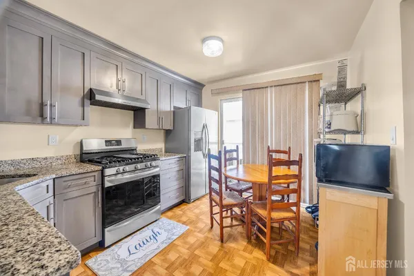 a kitchen with stainless steel appliances granite countertop a stove a sink and a refrigerator
