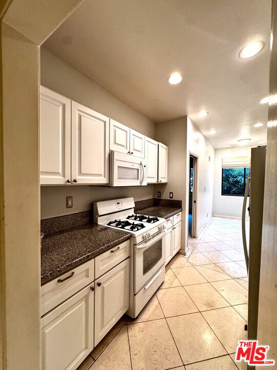 8455 Fountain Avenue, Unit 412 West Hollywood, CA 90069 - Photo 11 of 21 a kitchen with stainless steel appliances granite countertop a stove a sink and a refrigerator