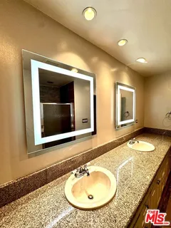 a bathroom with a granite countertop sink and a mirror