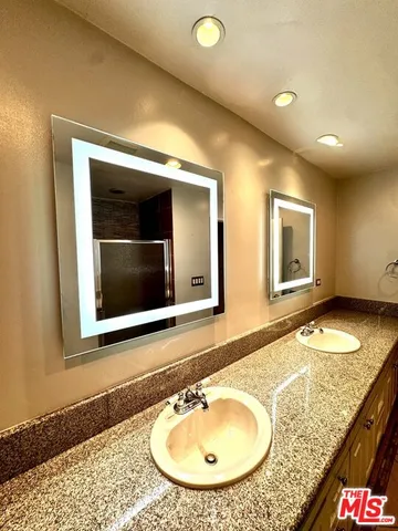 a bathroom with a granite countertop sink and a mirror