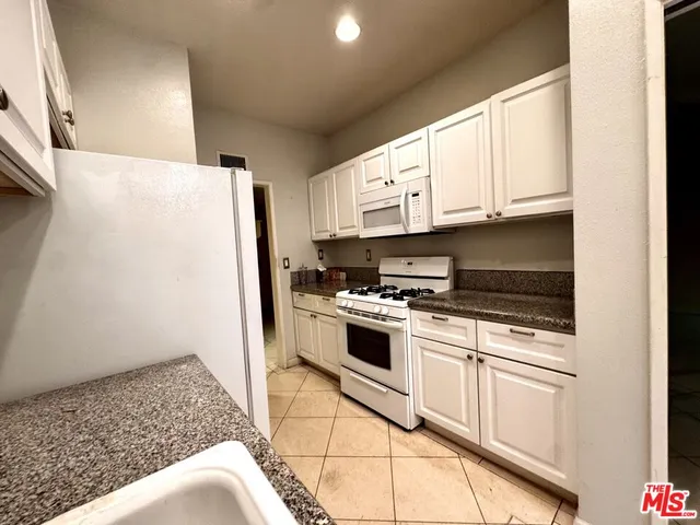 a kitchen with stainless steel appliances granite countertop a refrigerator sink and stove