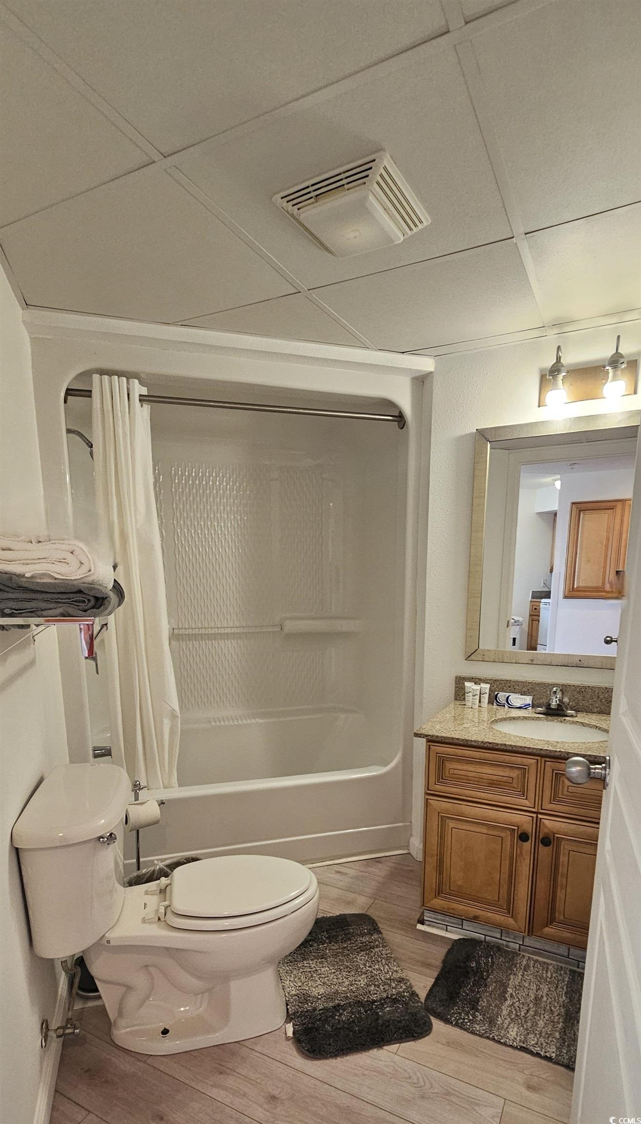 7100 North Ocean Boulevard, Unit 724 Myrtle Beach, SC 29572 - Photo 11 of 16 Full bathroom featuring vanity, light wood-style floors, shower / bath combination with curtain, and a paneled ceiling