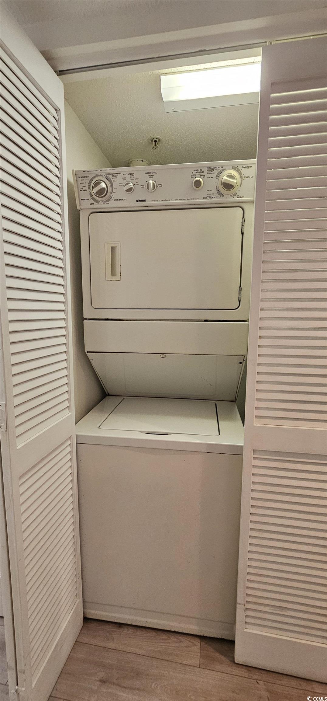 7100 North Ocean Boulevard, Unit 724 Myrtle Beach, SC 29572 - Photo 13 of 16 Laundry area featuring light wood-style flooring and stacked washer and clothes dryer