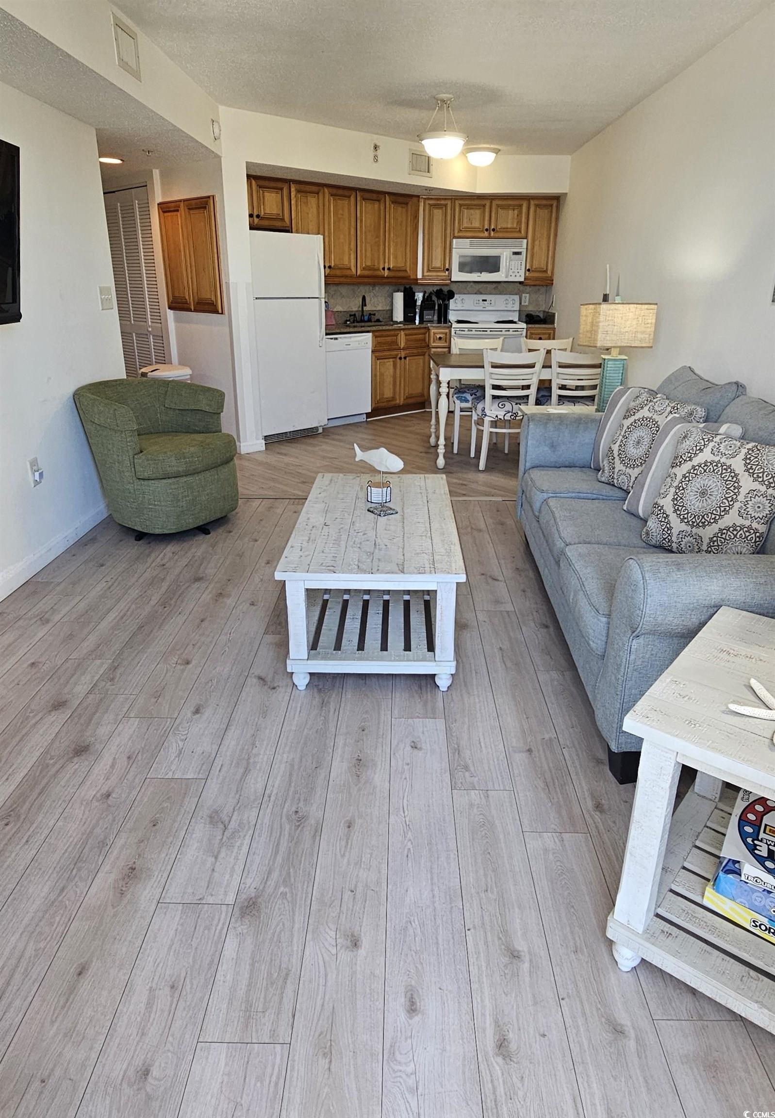 7100 North Ocean Boulevard, Unit 724 Myrtle Beach, SC 29572 - Photo 6 of 16 Living area with light wood finished floors and a textured ceiling