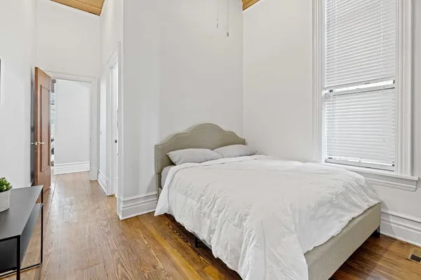 a bedroom with a bed and wooden floor
