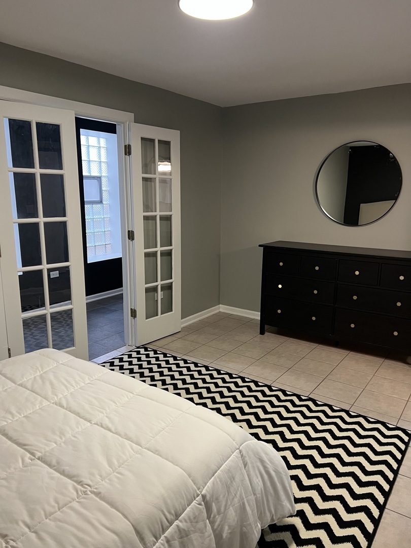 1400 West Chestnut Street, Unit 1 Chicago, IL 60642 - Photo 19 of 24 a bedroom with a bed and a large window