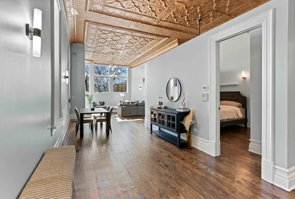 a living room with furniture a window entryway and wooden floor