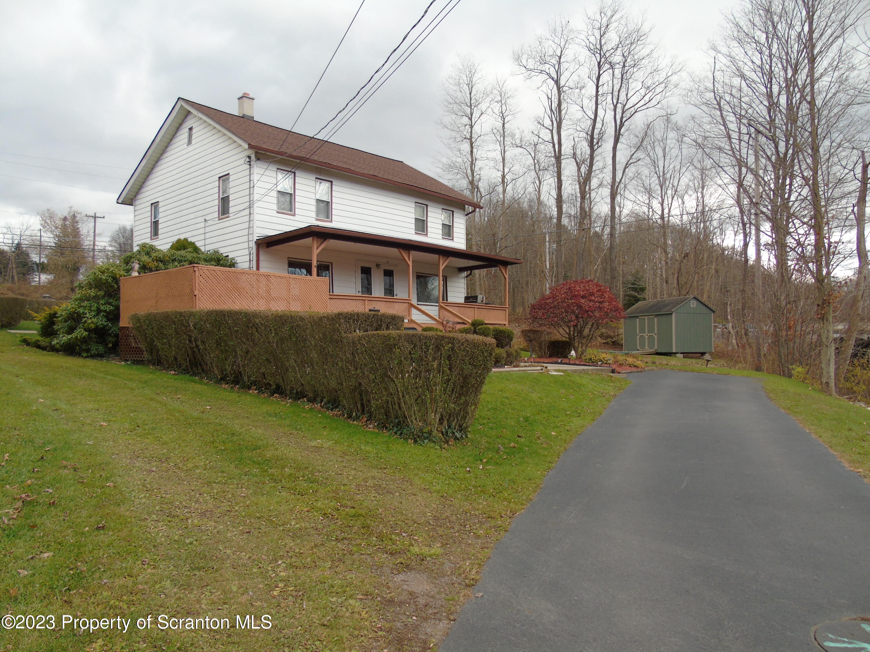 a view of a house with a big yard and large trees