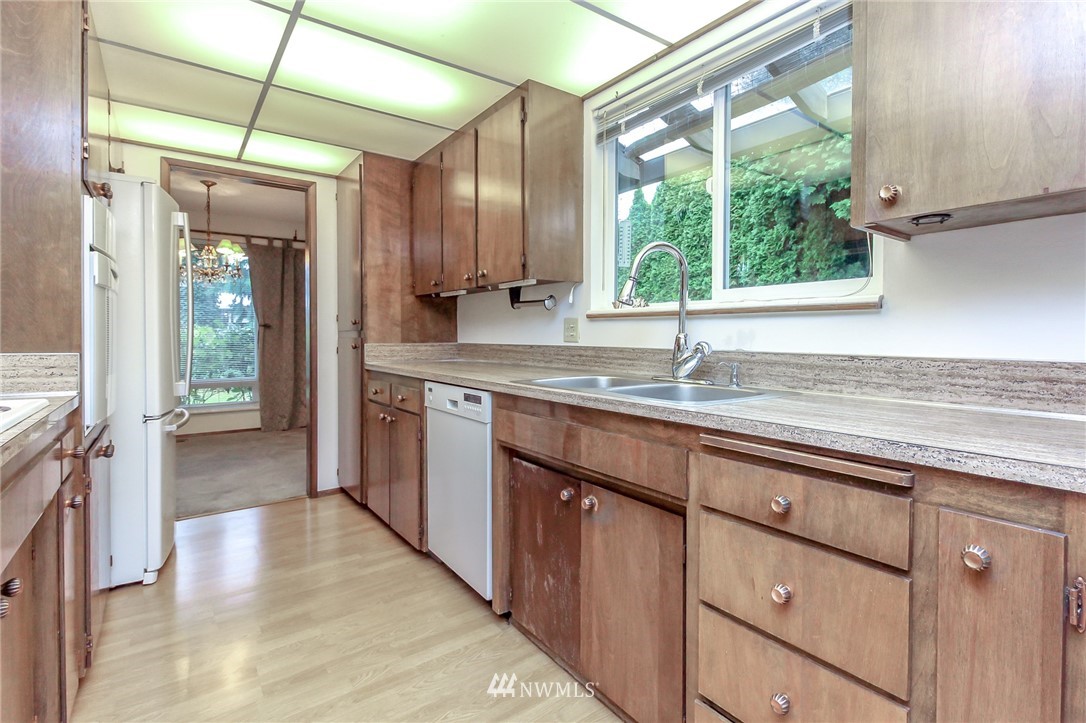 4615 Northeast 24th Street Renton, WA 98059 - Photo 13 of 40 a kitchen with stainless steel appliances granite countertop a sink a counter space wooden floor and a window