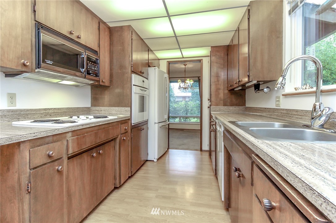 4615 Northeast 24th Street Renton, WA 98059 - Photo 14 of 40 a kitchen with kitchen island granite countertop a sink stainless steel appliances and cabinets