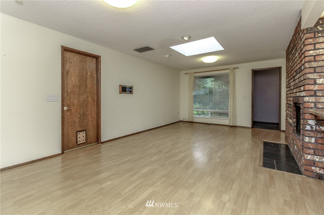 4615 Northeast 24th Street Renton, WA 98059 - Photo 16 of 40 an empty room with wooden floor cabinet and windows
