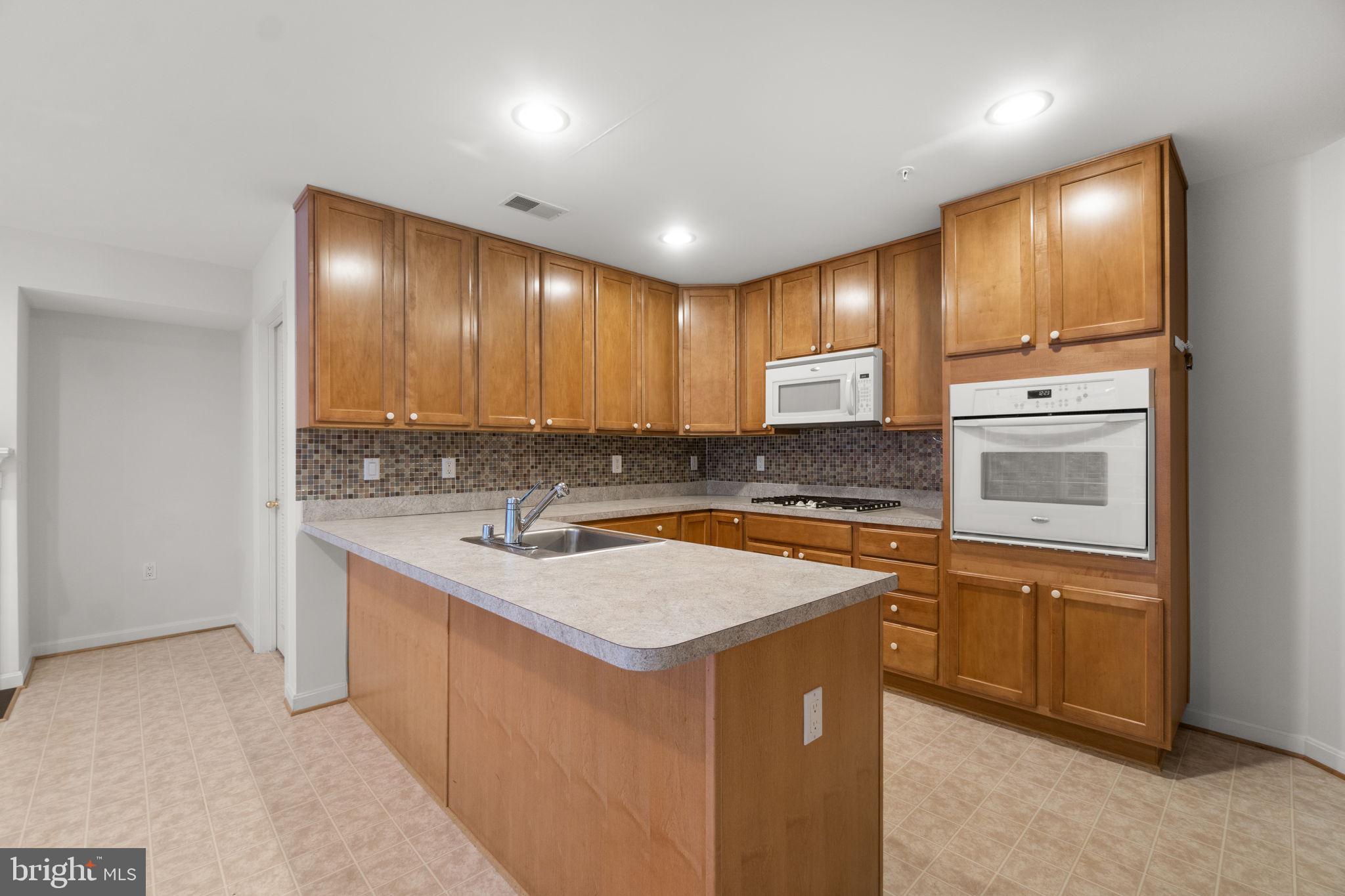 9510 Coyle Road, Unit 109 Owings Mills, MD 21117 - Photo 15 of 41 a kitchen with a sink stove and cabinets