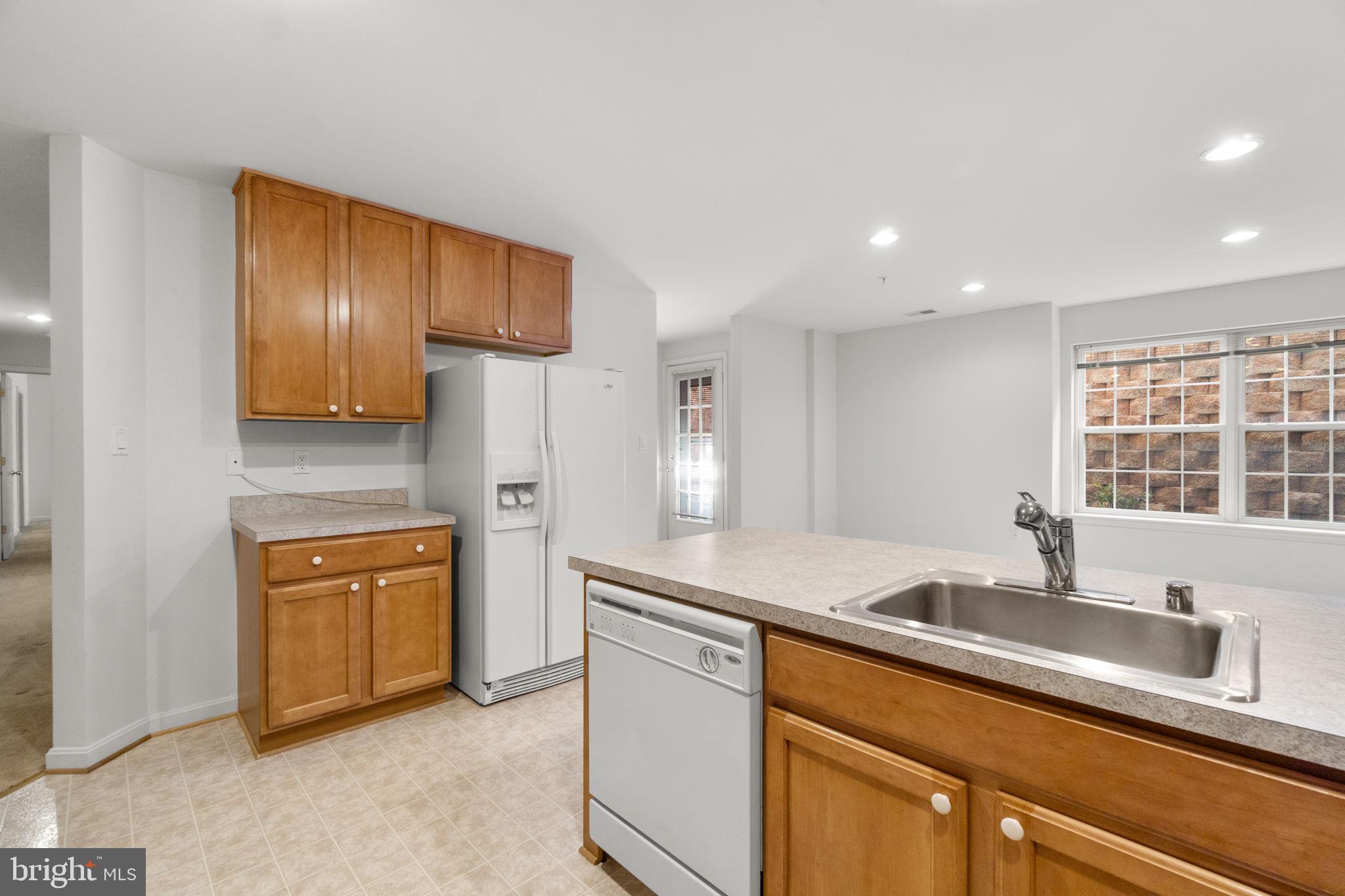 9510 Coyle Road, Unit 109 Owings Mills, MD 21117 - Photo 18 of 41 a kitchen with stainless steel appliances granite countertop a sink and a refrigerator
