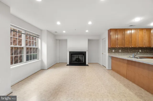 a view of an empty room with a fireplace and a window