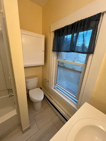 a bathroom with a toilet a sink and mirror