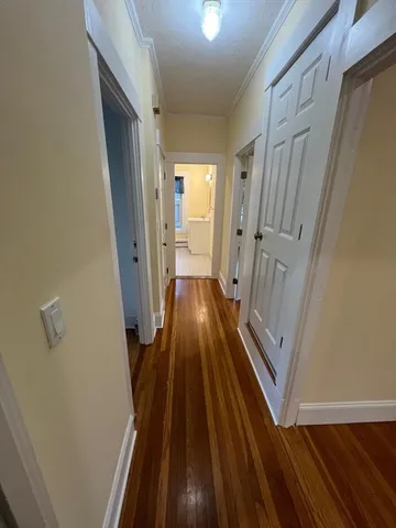 a view of a hallway with wooden floor and staircase