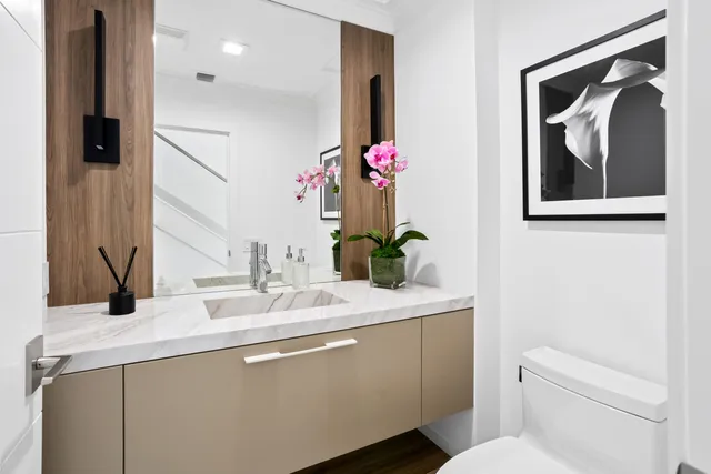 a bathroom with a granite countertop sink a mirror and a shower