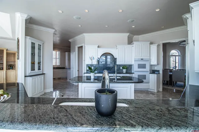 a kitchen with stainless steel appliances kitchen island granite countertop a dining table and chairs