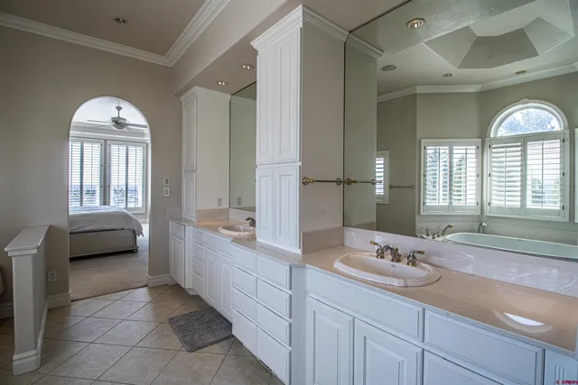 a spacious bathroom with a double vanity sink a mirror and a bathtub